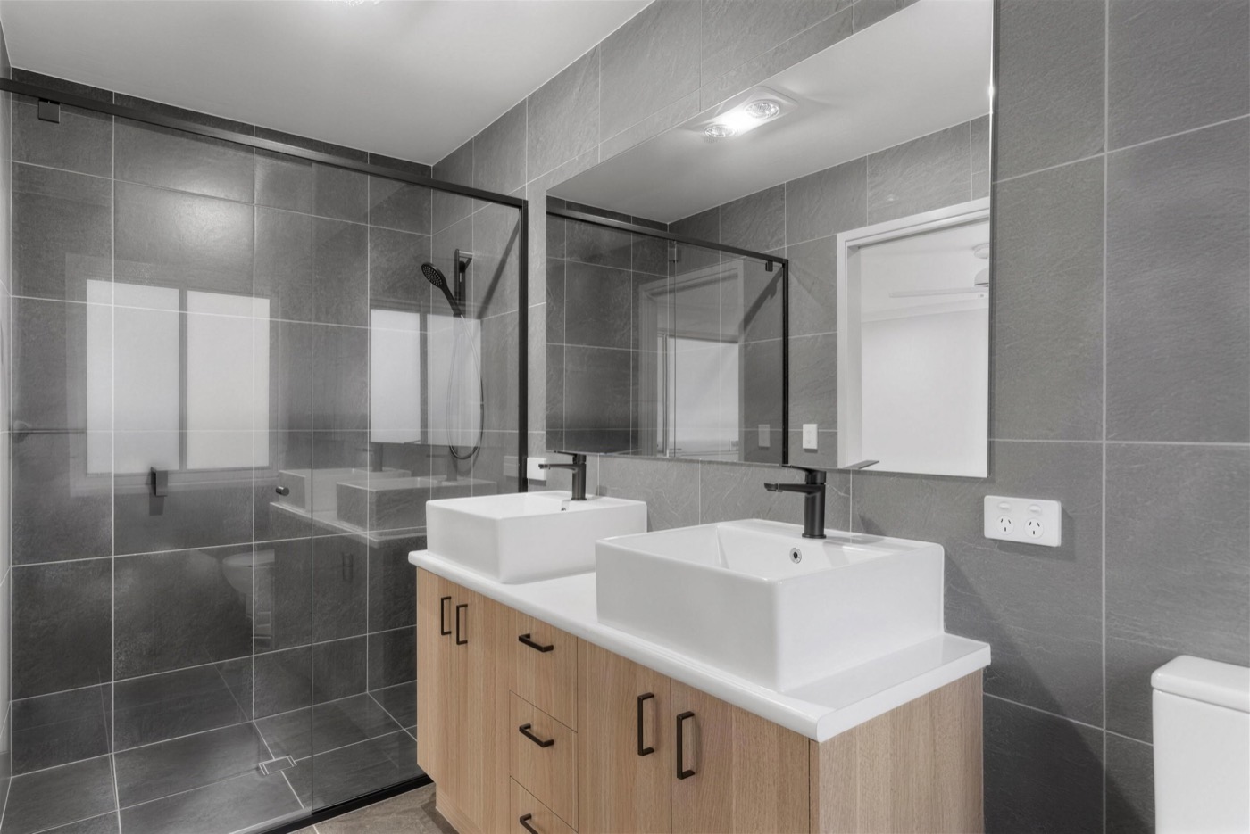 Renovated bathroom with dual vanity by Pocock Constructions
